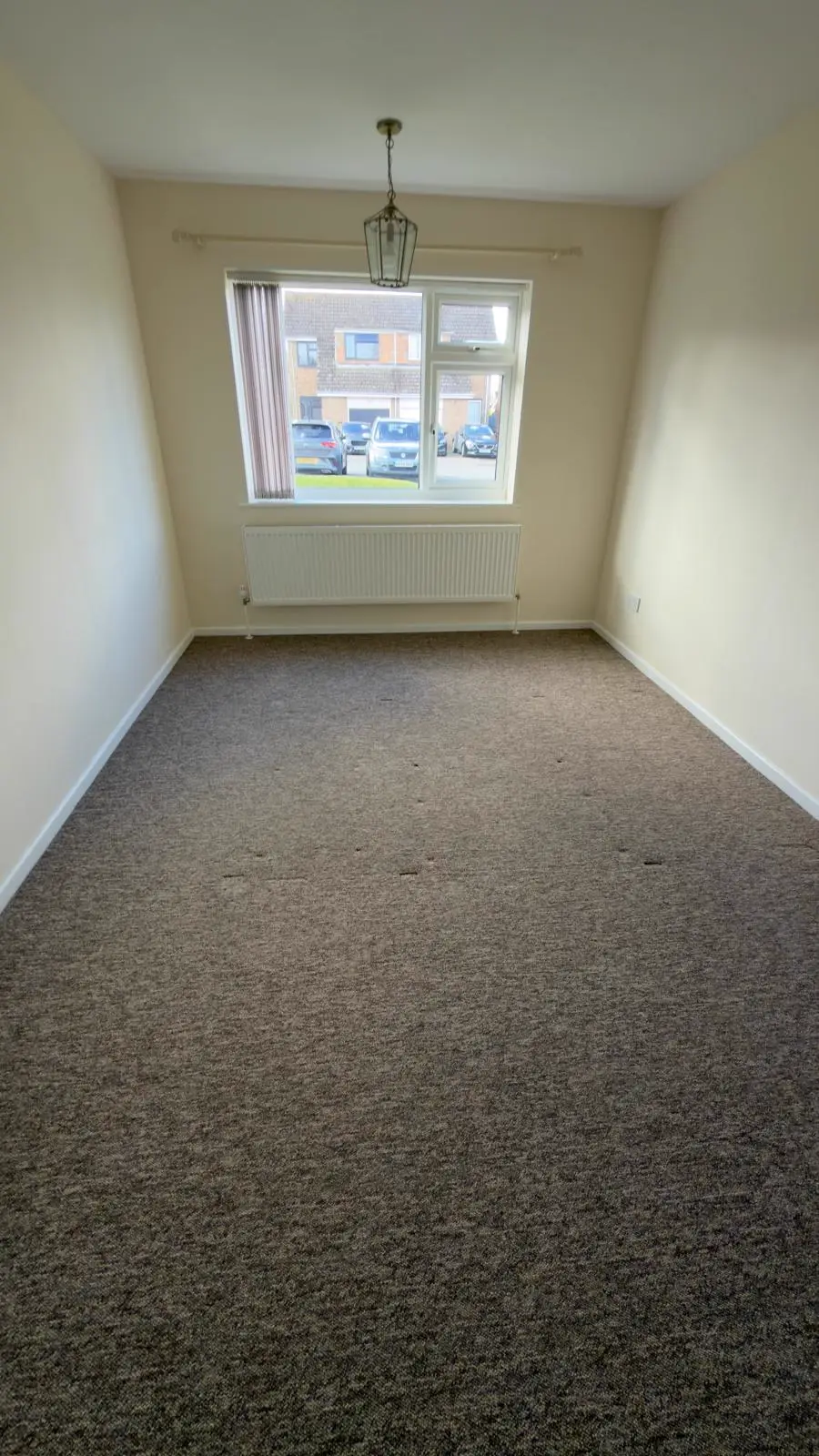 Empty carpeted room after cleaning with a bright window