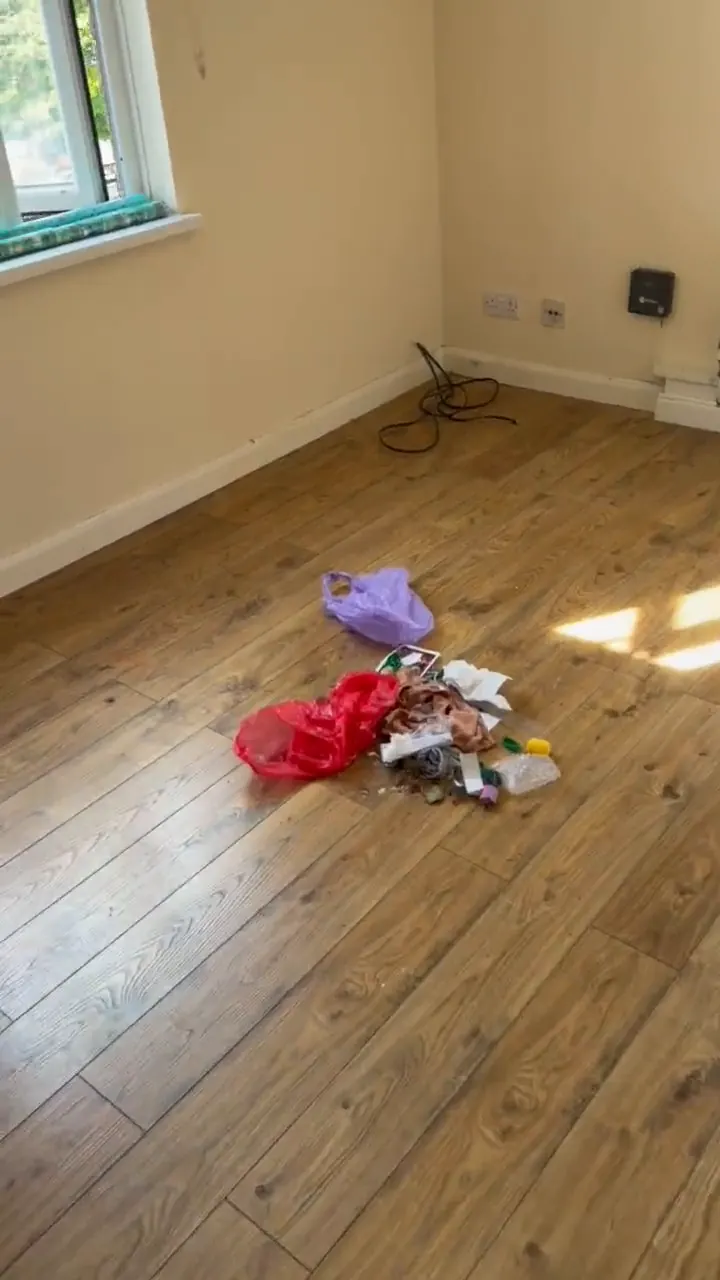 Room with a leaf-pattern blind and wooden floor, with items left on the floor